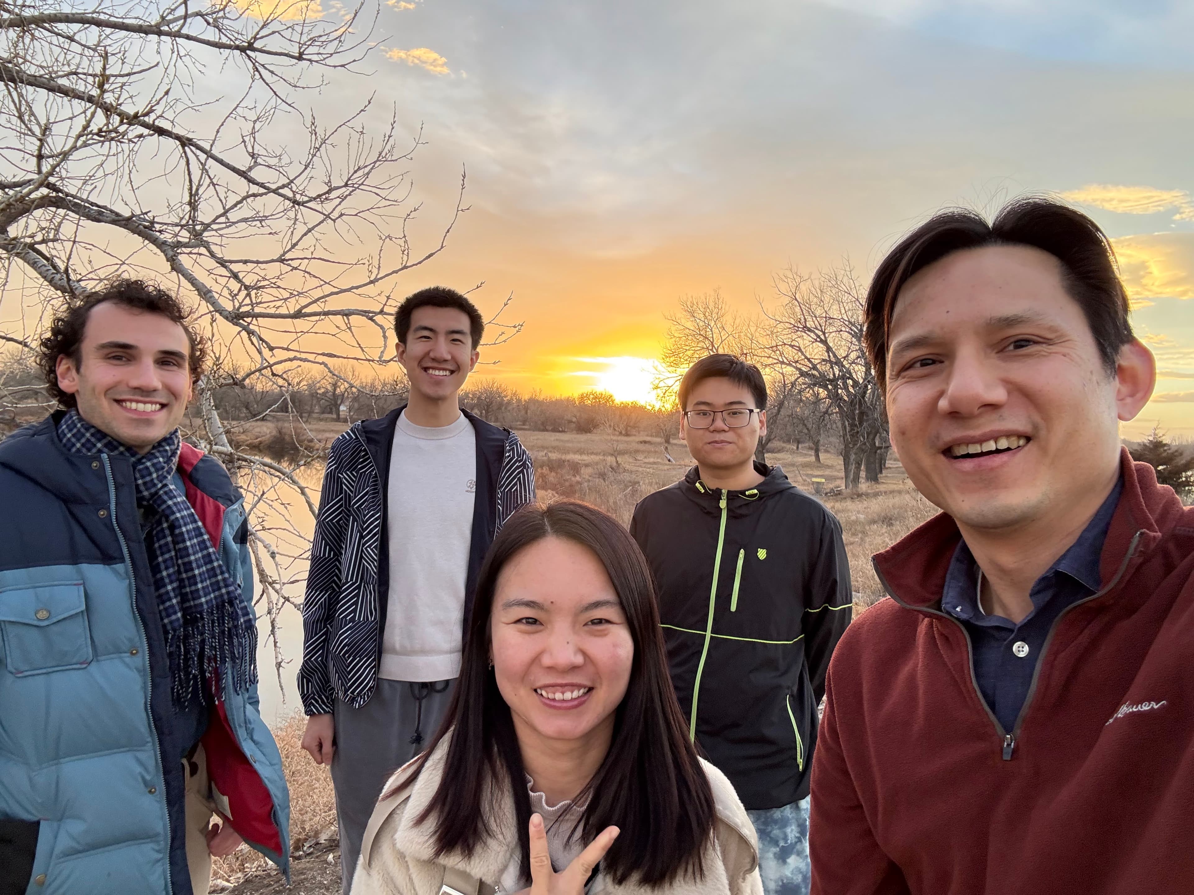 Un pequeño grupo de amigos de Young Disciples juntos al aire libre al atardecer.